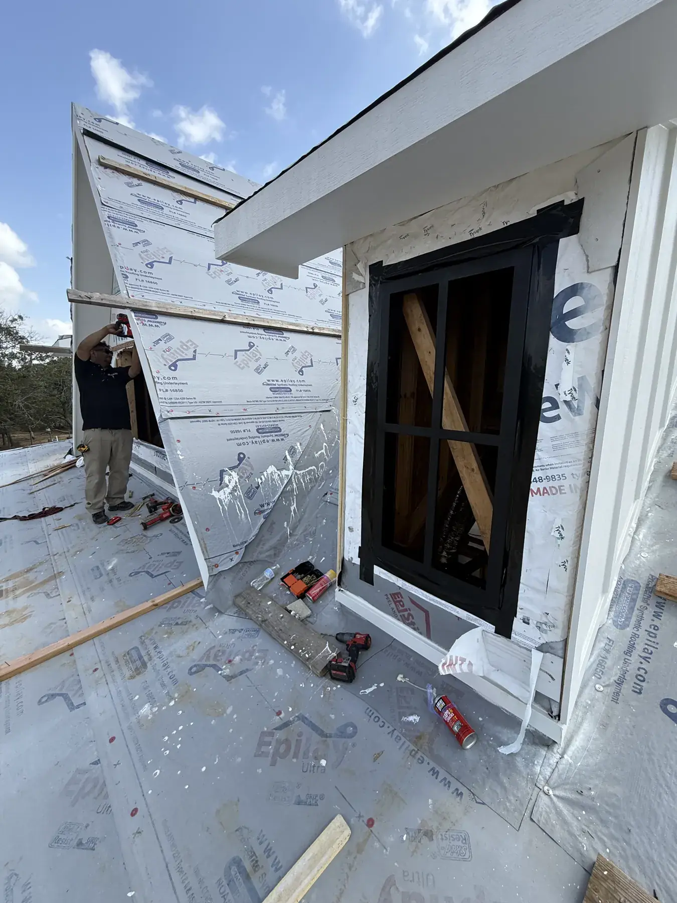Black window installed in a dormer during construction