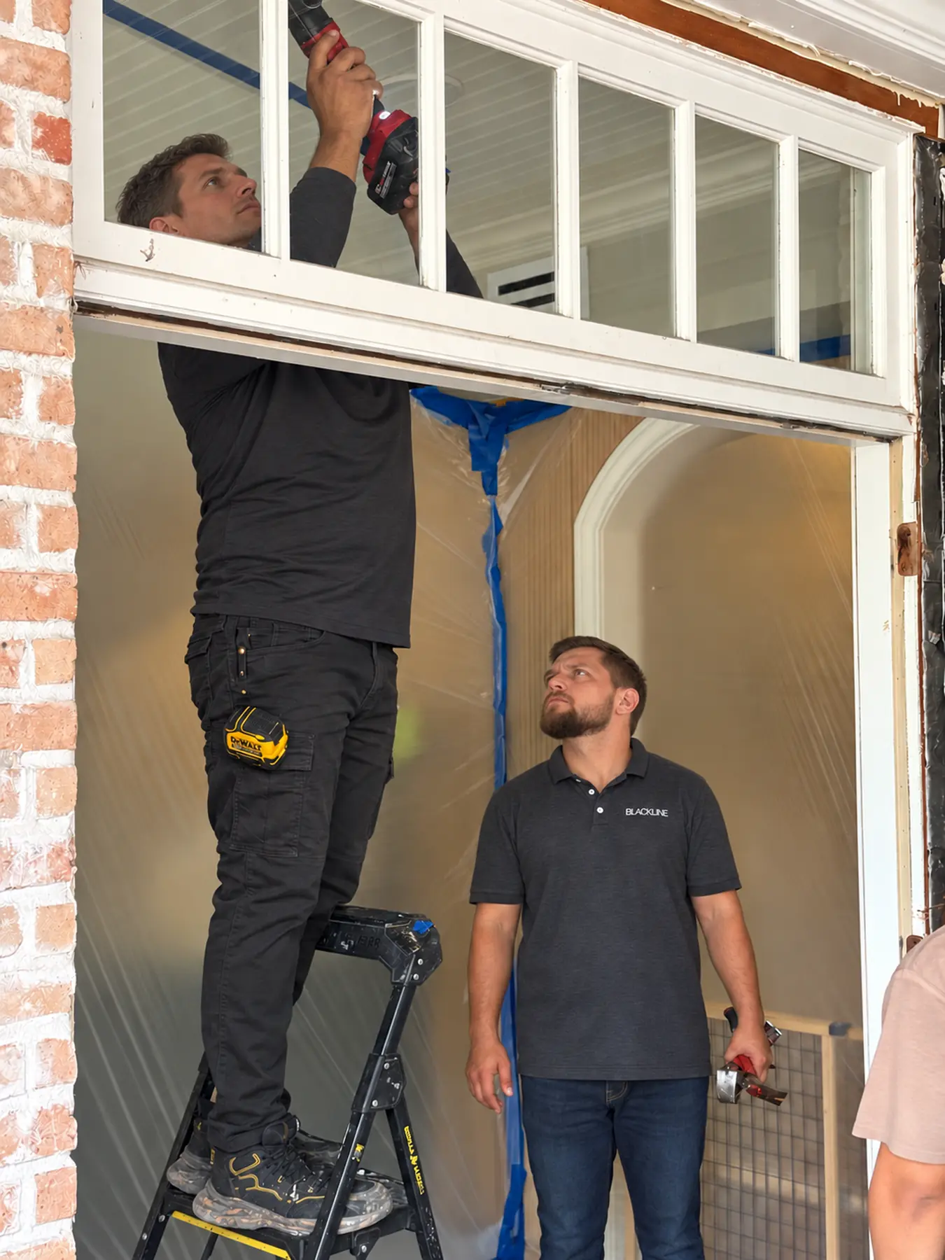 Blackline team members on a job site installing an iron door transom