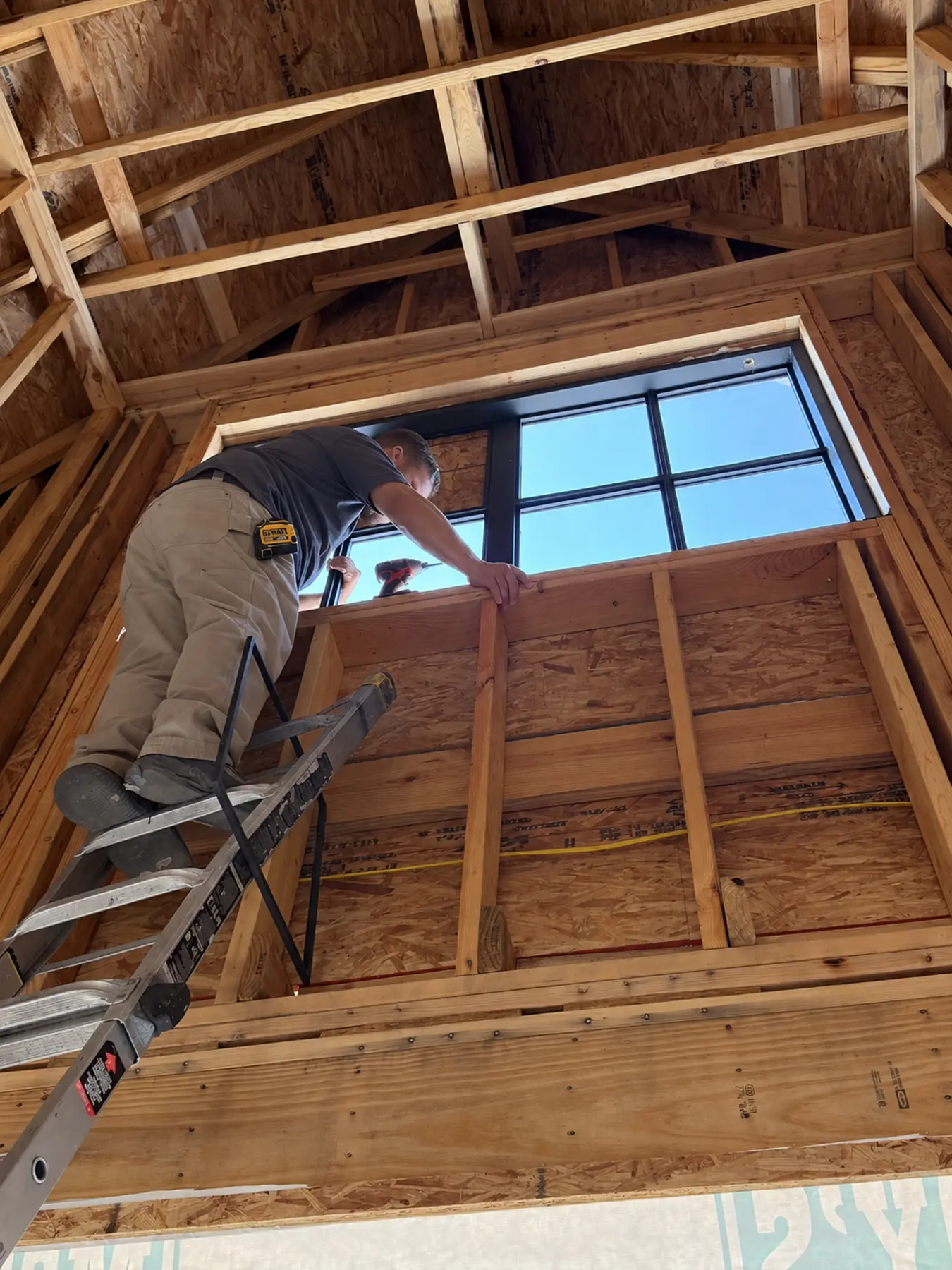 Installer setting a high window in a vaulted room