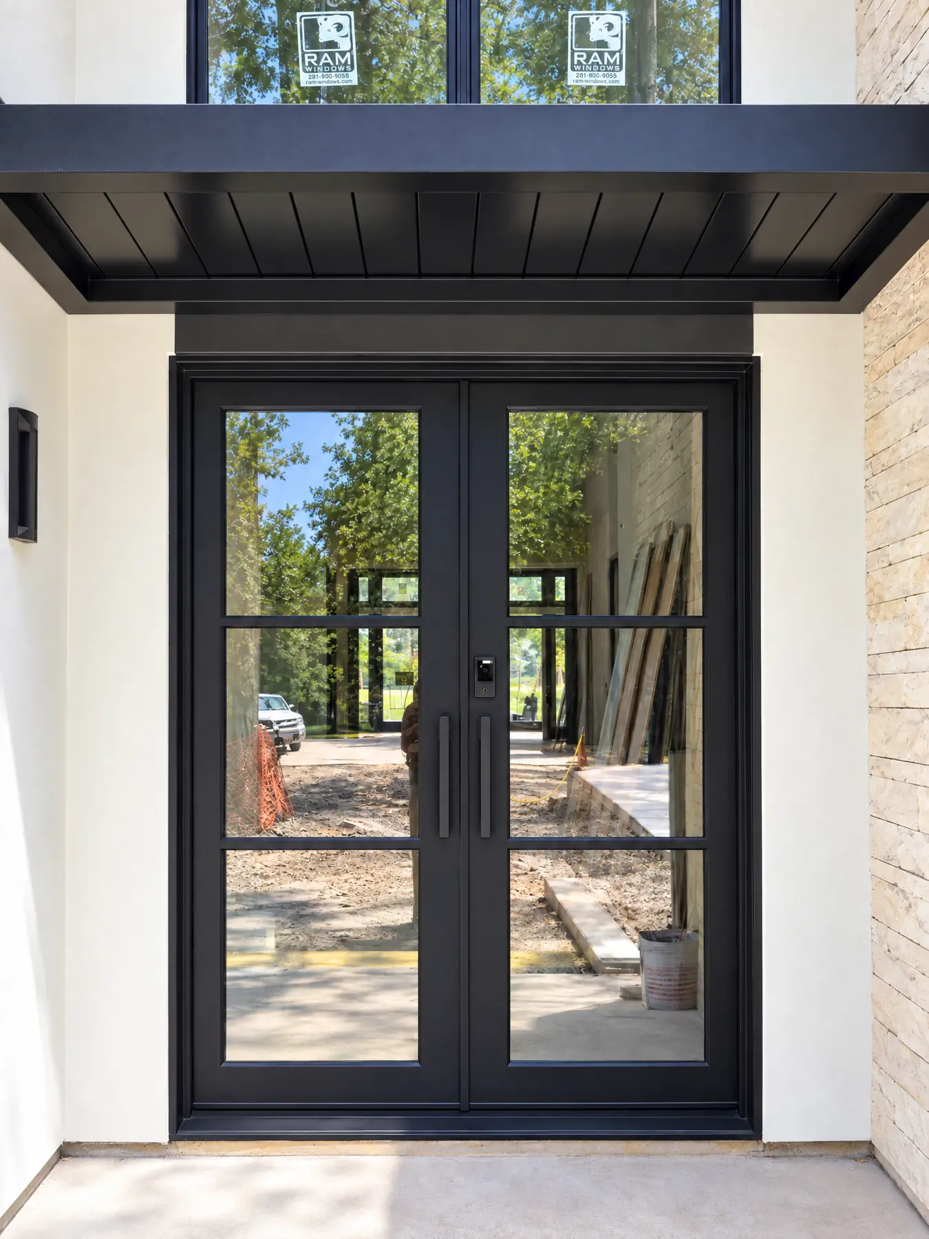 Black double iron front doors with clear glass under a covered entry in Texas