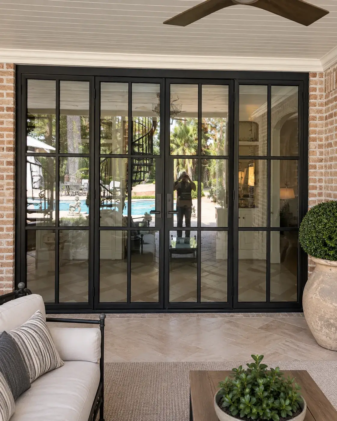 Four-panel black steel French door system with insulated glass on a Texas porch