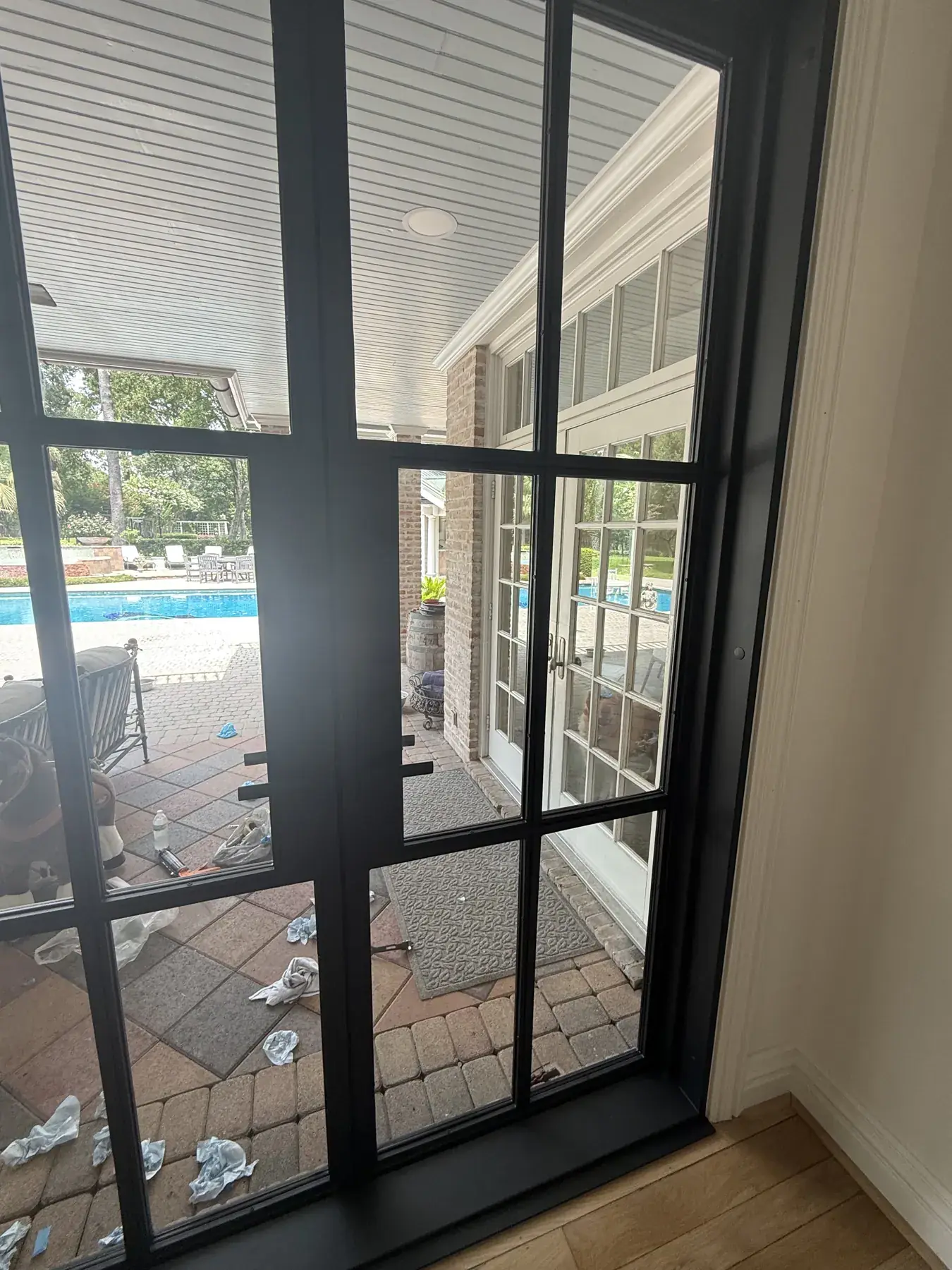 Black steel French patio doors with divided glass facing a pool at a Houston-area home