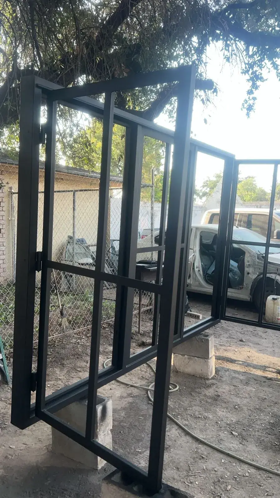 Black iron pivot door frame with divided lites before installation
