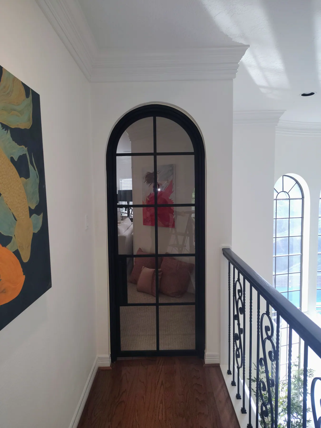 Arched iron door beside an interior railing