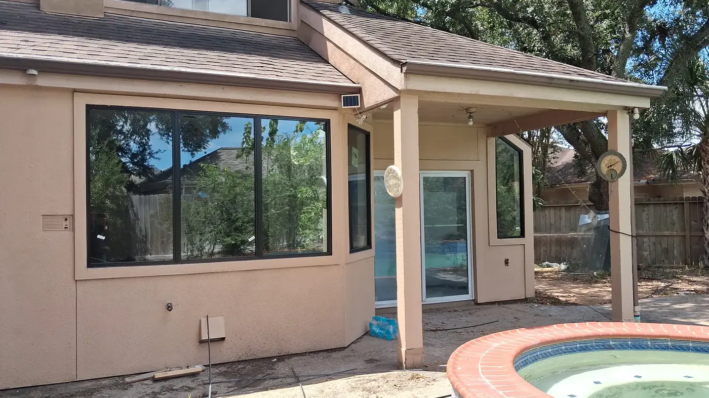 Black windows across the back of a home with a patio