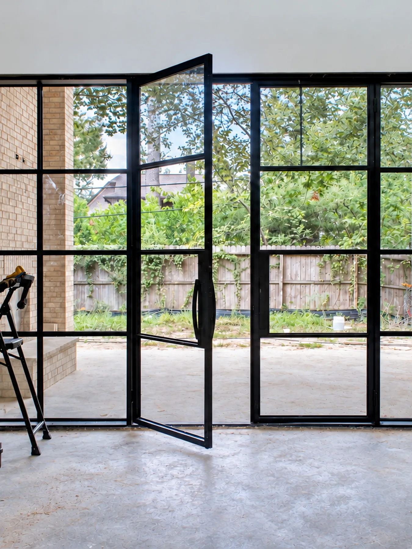 Steel glass wall with pivot door by Blackline Premium Solutions