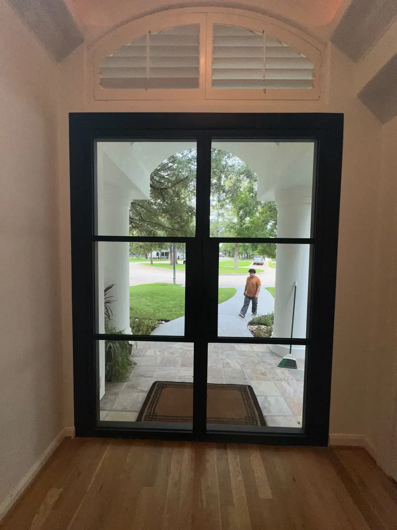 Black iron double doors at the end of a hallway in a San Antonio home