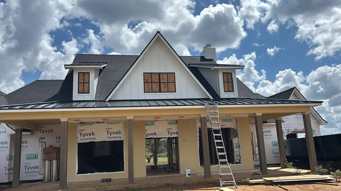 Farmhouse-style home with black windows under construction near Houston